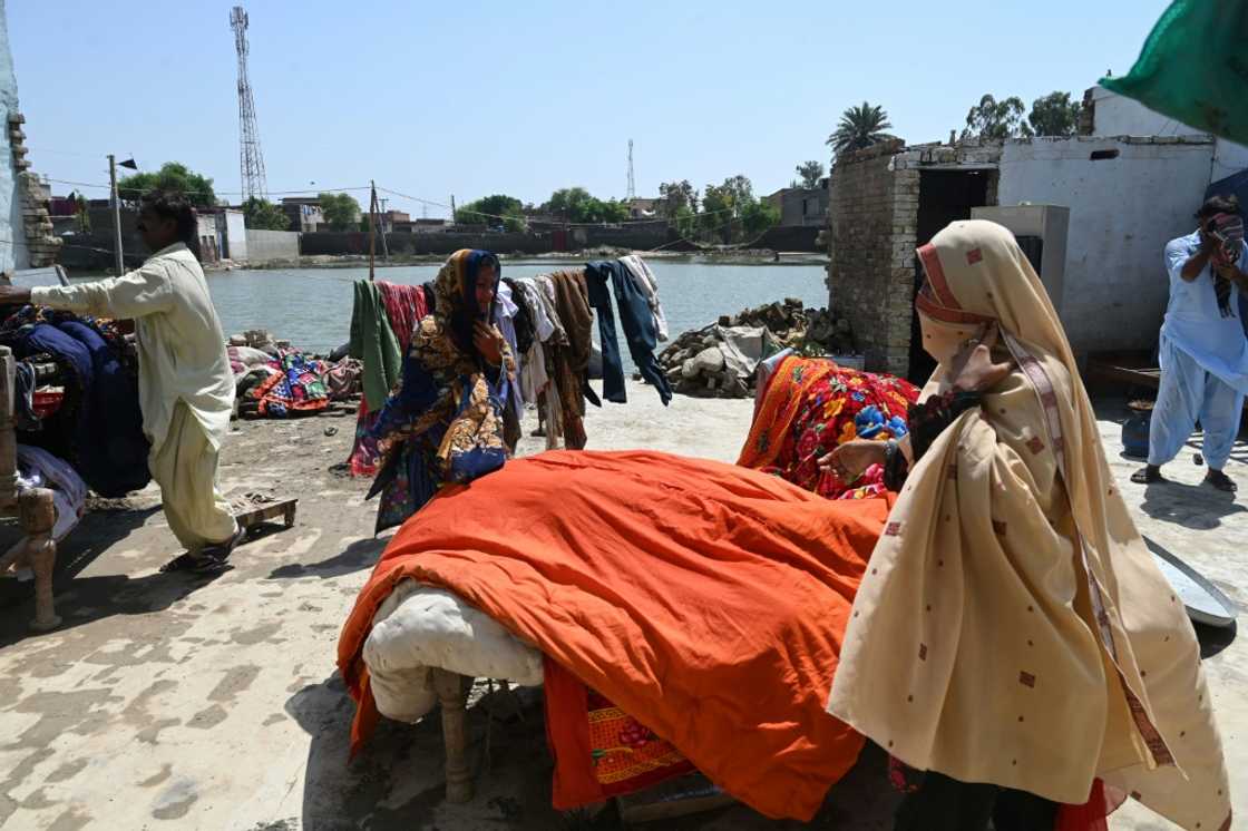 Mureed Hussain and other family members lay their belongings out in the sun to dry after their home was inundated with flood water Mureed Hussain and other family members lay their belongings out in the sun to dry after their home was inundated with flood water