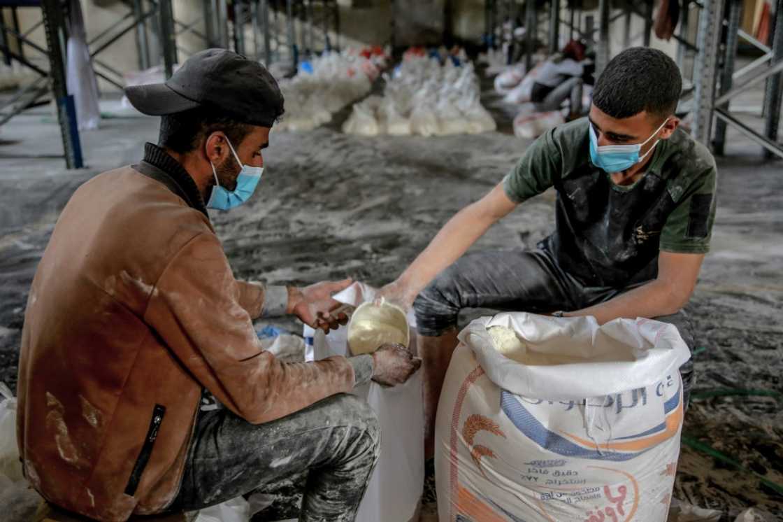 Workers ration out flour during the distribution of humanitarian aid in Gaza City Workers ration out flour during the distribution of humanitarian aid in Gaza City