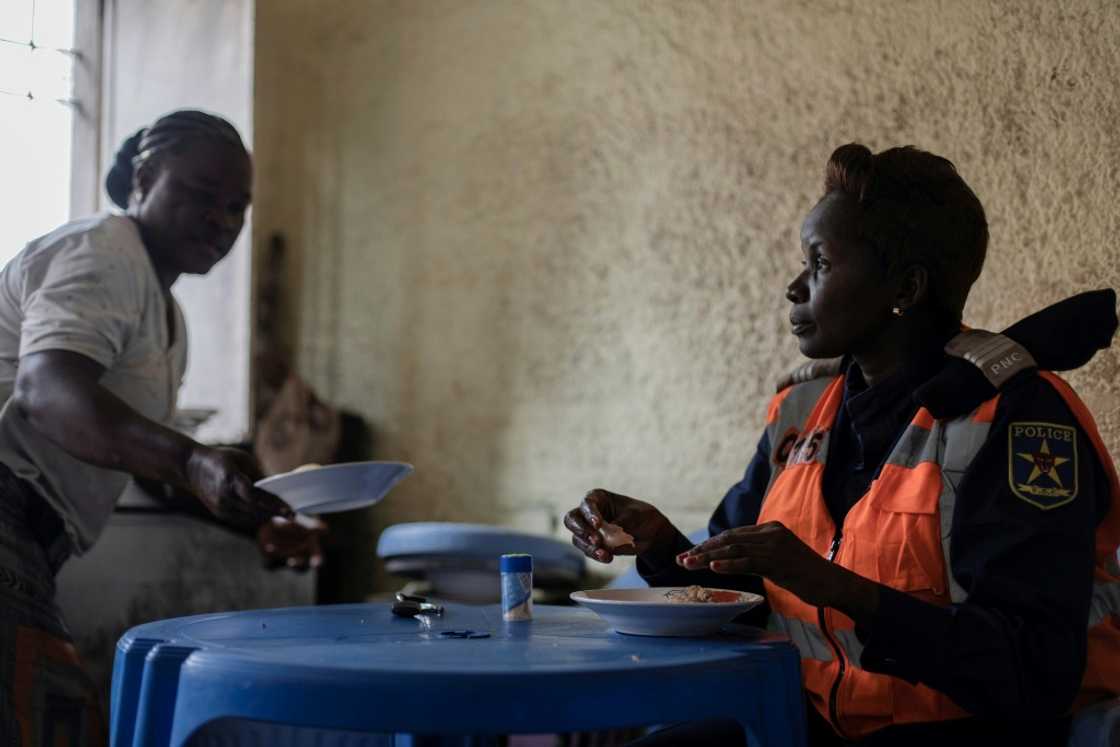 Shift over: Cecile Bakindo eats in a restaurant next to her checkpoint after directing traffic all morning Shift over: Cecile Bakindo eats in a restaurant next to her checkpoint after directing traffic all morning