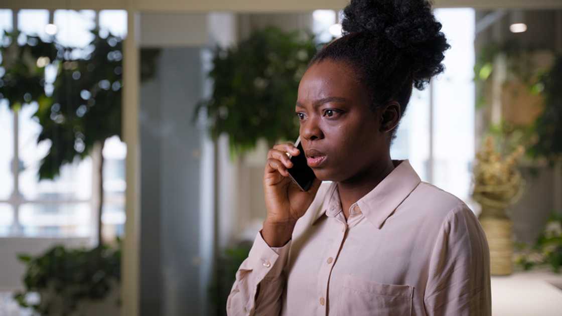 A woman speaks on the phone at her mansion at dusk. A woman speaks on the phone at her mansion at dusk.