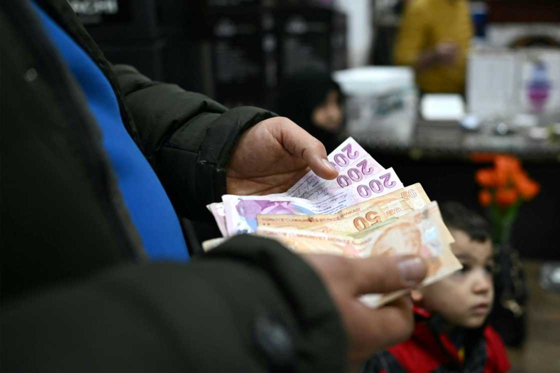 A man counts Turkish lira at a shop in Dana, which has become a retail hotspot since Assad's fall