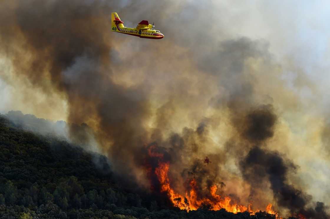 French fire-fighting aircraft fly over burning forests near Gignac, southern France on July 26, 2022 as the country endured a dry summer with blazes destroying numerous forests French fire-fighting aircraft fly over burning forests near Gignac, southern France on July 26, 2022 as the country endured a dry summer with blazes destroying numerous forests