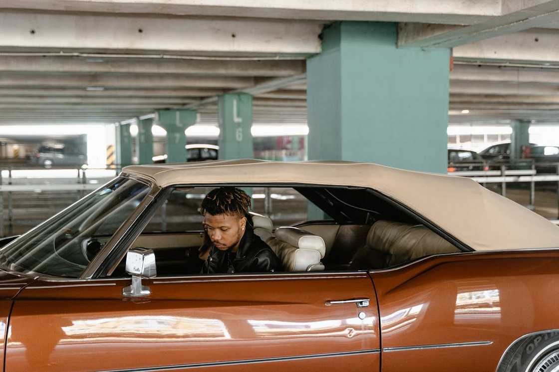 A man sits alone in his parked car. A man sits alone in his parked car.