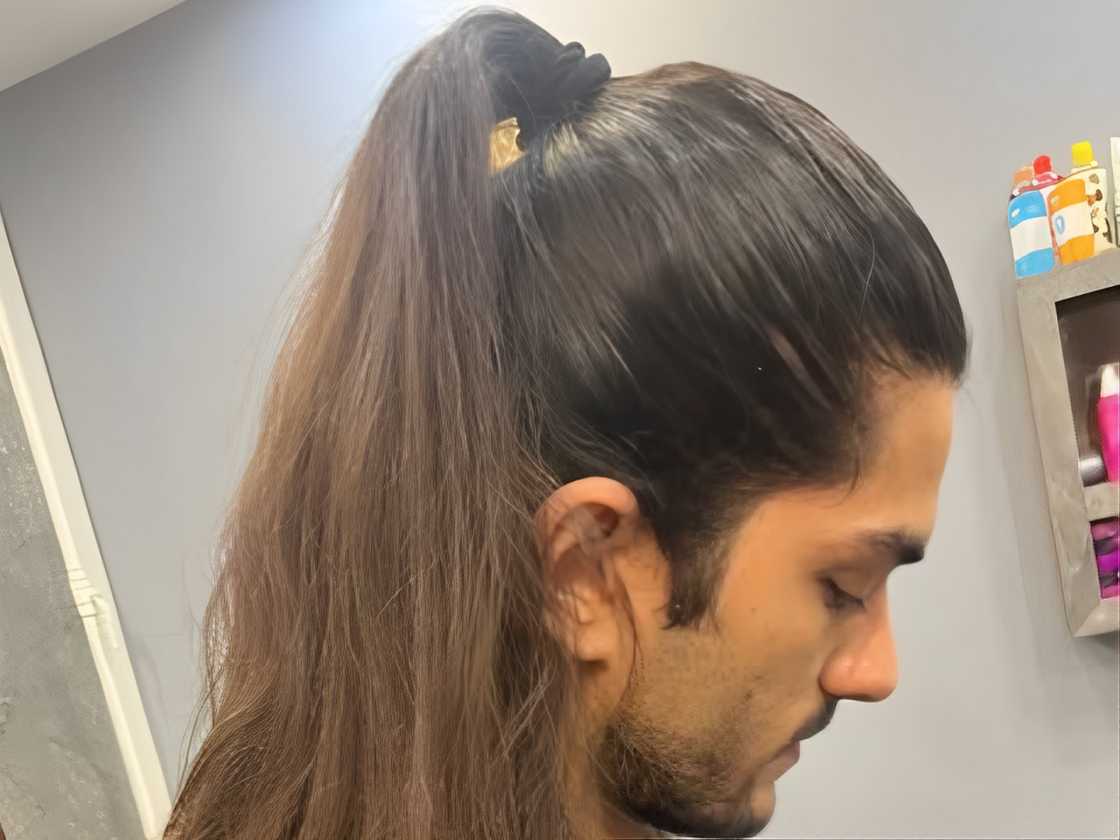 A man is rocking a high ponytail hairstyle A man is rocking a high ponytail hairstyle