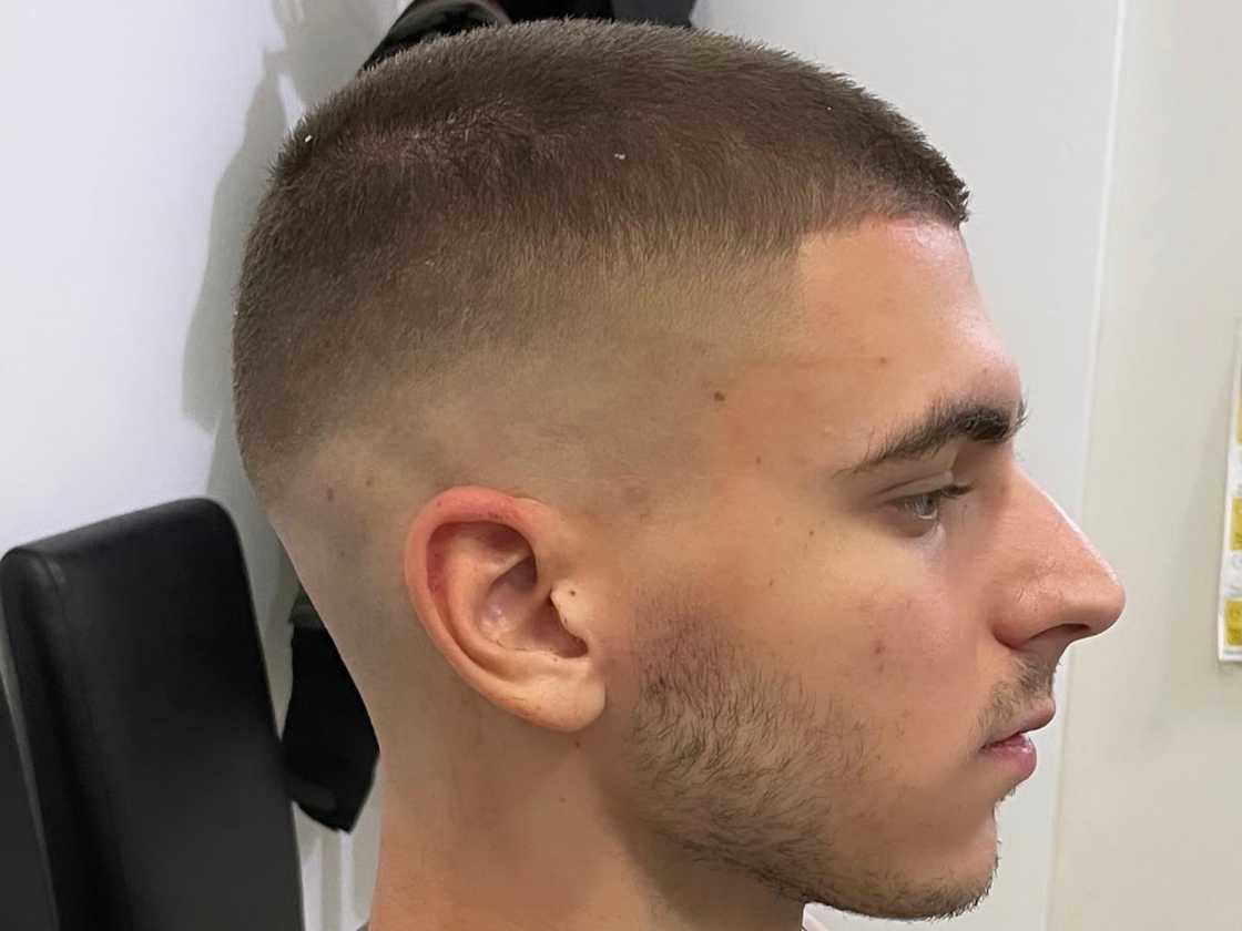 Buzz cut with high skin fade and patched beard