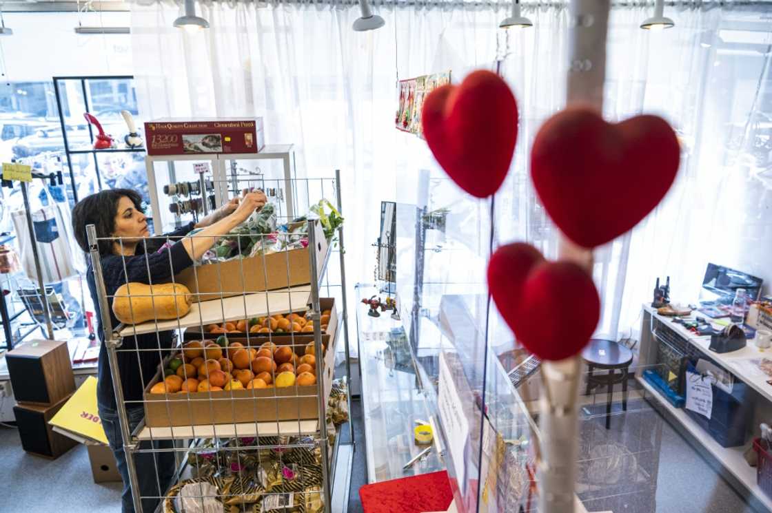 A volunteer stacks donated food in a Red Cross shop in Stockholm