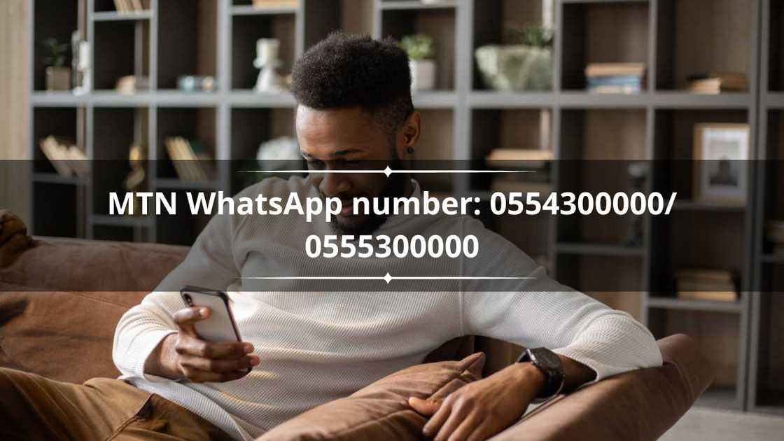 A man in a white sweater using a smartphone. A man in a white sweater using a smartphone.