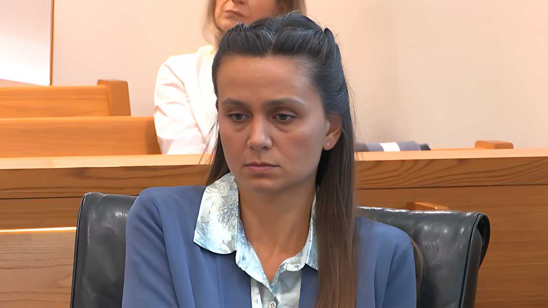 Ashley Benefield seated in court wearing a blue blouse with a patterned collar. Ashley Benefield seated in court wearing a blue blouse with a patterned collar.