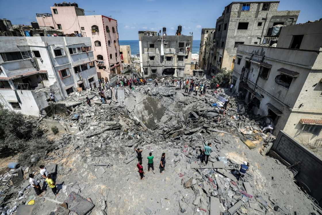Palestinians inspect the ruins of a building destroyed by an Israeli air strike in Gaza City, on August 6, 2022 Palestinians inspect the ruins of a building destroyed by an Israeli air strike in Gaza City, on August 6, 2022