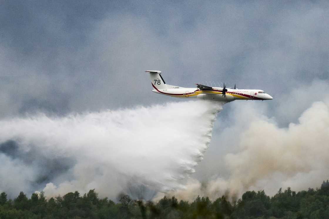 A De Havilland Canada Dash 8-400 MR aircraft drops water over a wildfire raging in the Monts d'Arree, near Brennilis, Brittany. A De Havilland Canada Dash 8-400 MR aircraft drops water over a wildfire raging in the Monts d'Arree, near Brennilis, Brittany.
