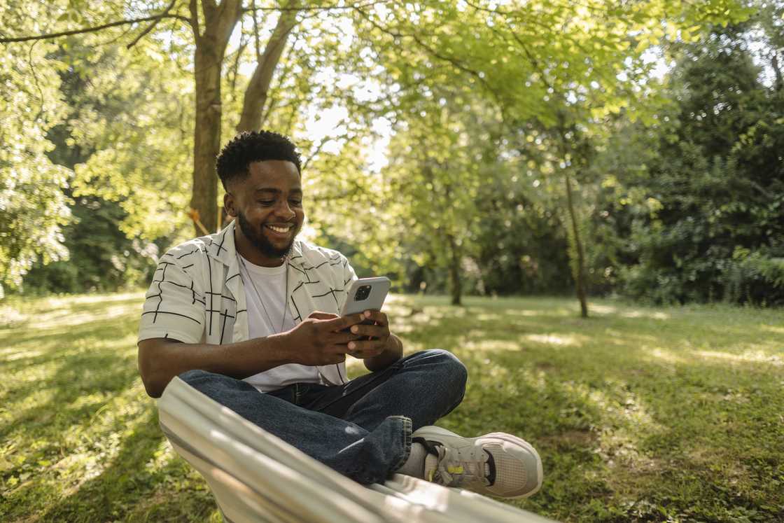 Person sitting peacefully in nature, sunlight through trees Person sitting peacefully in nature, sunlight through trees
