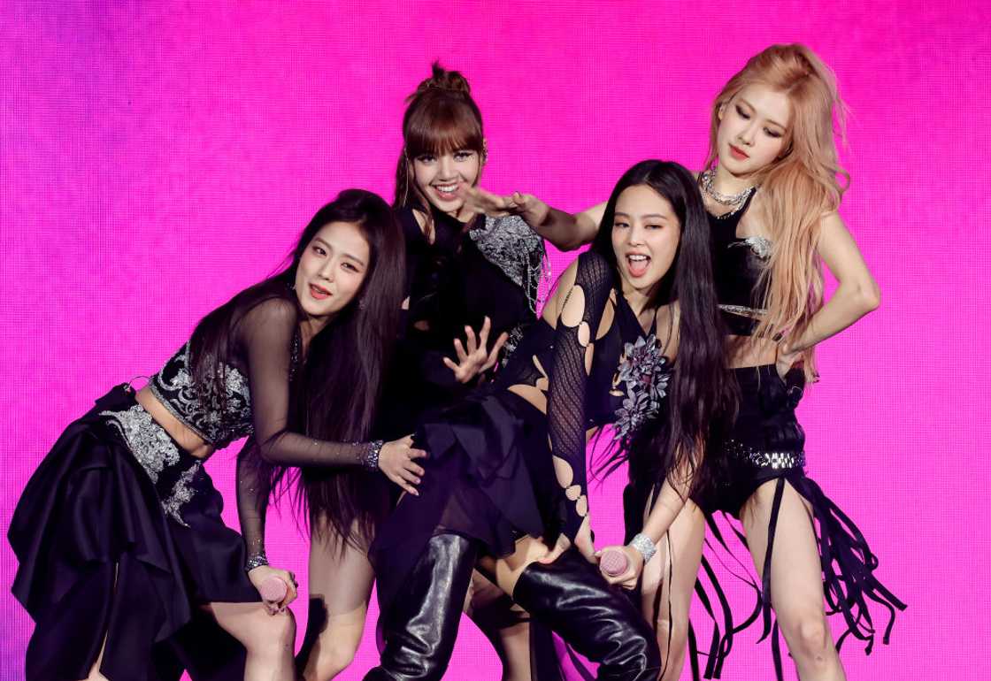 Jisoo, Lisa, Jennie, and Rosé of BLACKPINK, one of the most popular K-pop groups, pose for a photo in black costumes