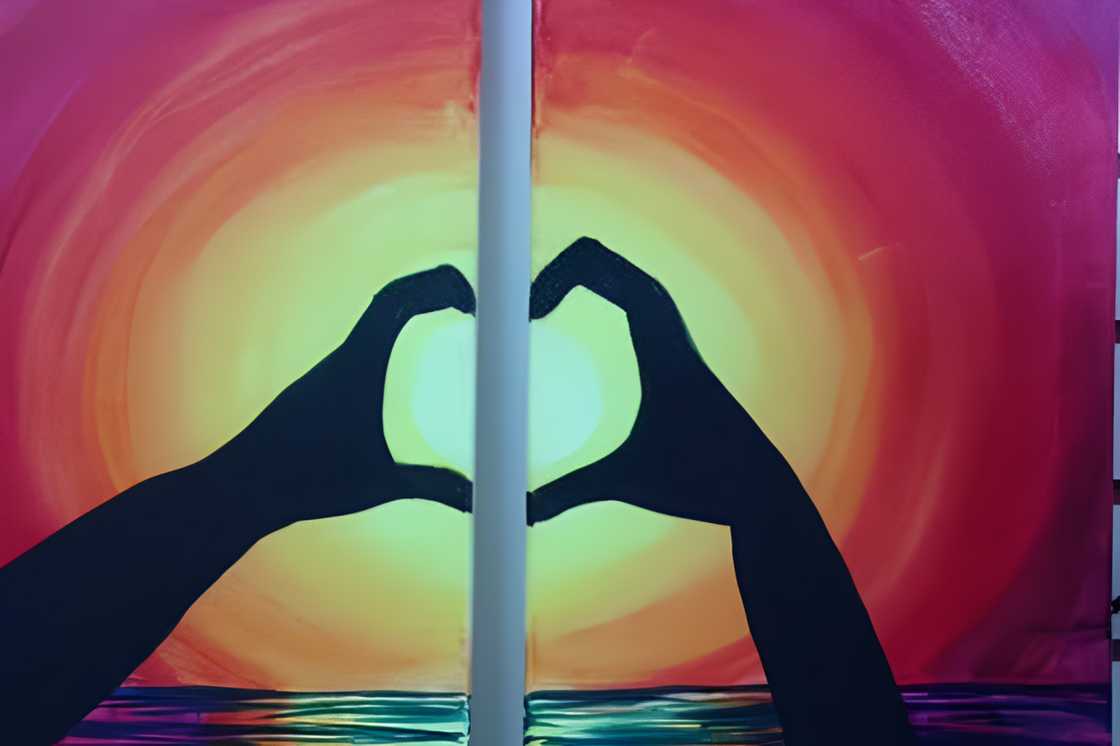 Two separate hands forms a heart shape against a sunny background Two separate hands forms a heart shape against a sunny background