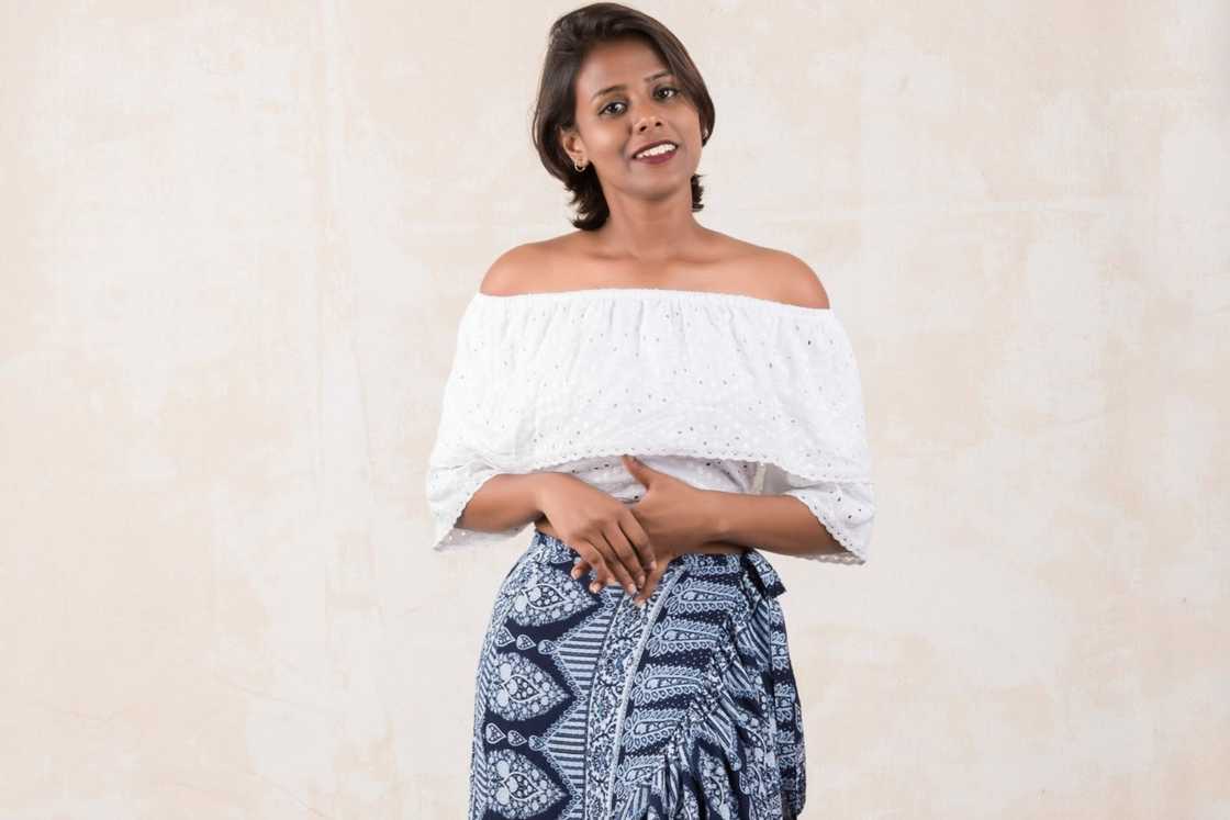 A lady with a white top and an African printed skirt