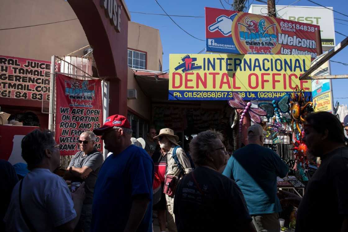 Visitors from the United States walk past a dental office in downtown Los Algodones, near the US-Mexico border in 2017 Visitors from the United States walk past a dental office in downtown Los Algodones, near the US-Mexico border in 2017