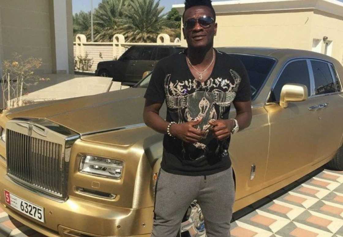 Asamoah Gyan poses with his fleet of cars from his mansion Asamoah Gyan poses with his fleet of cars from his mansion