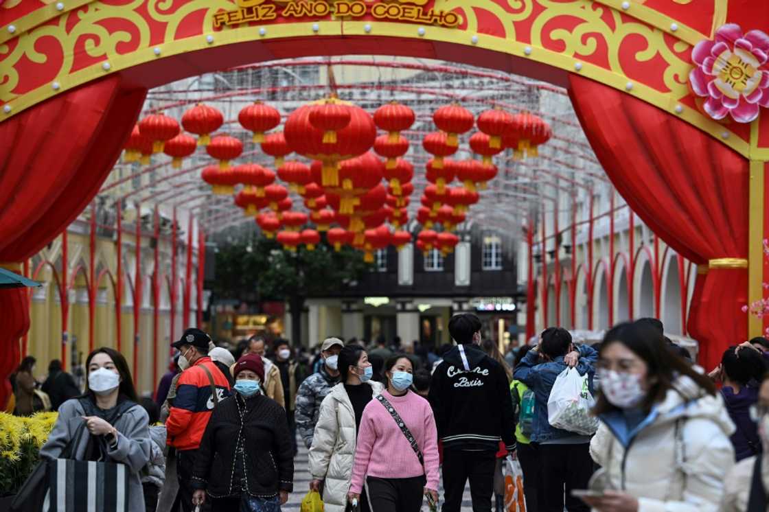 Tourists from mainland China stroll down a street in Macau Tourists from mainland China stroll down a street in Macau