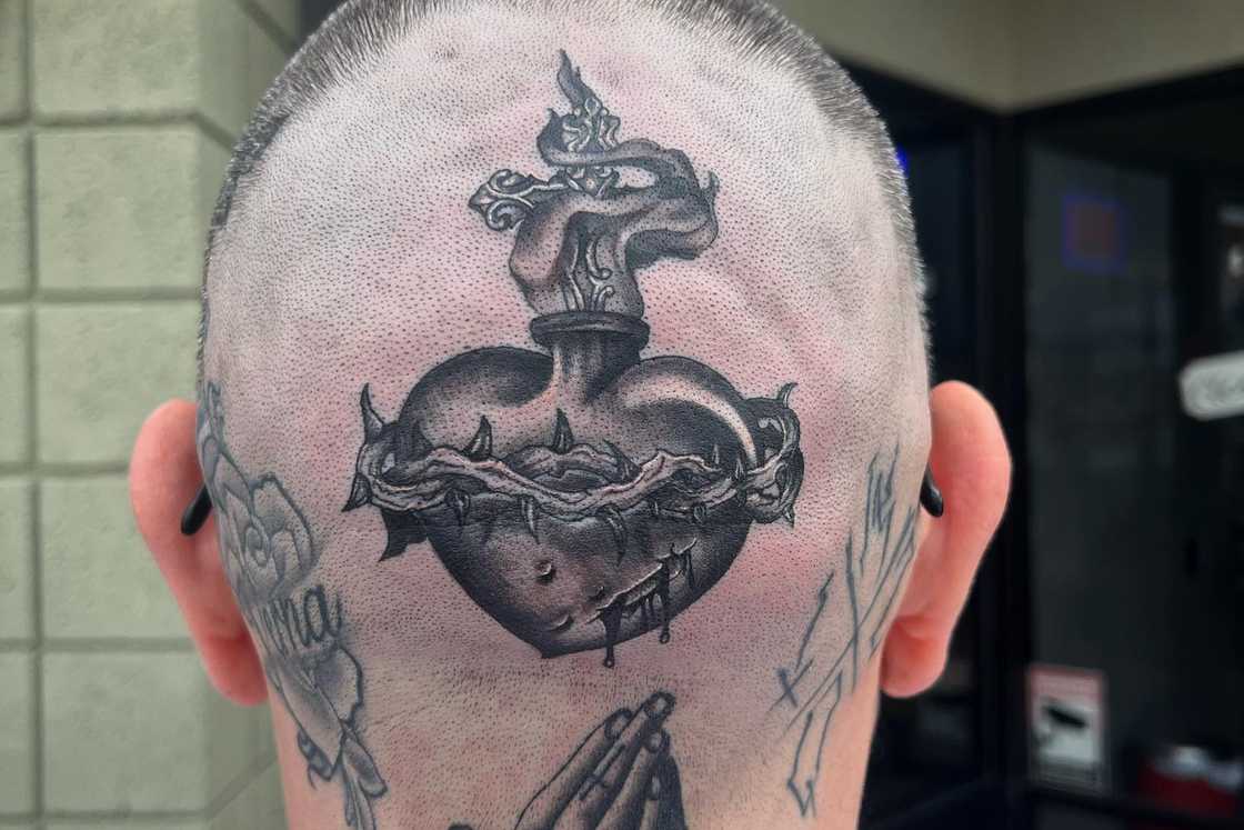 A white man with a sacred heart tattoo at the back of his head