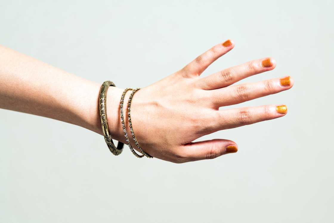 A lady's hand with gold bangles A lady's hand with gold bangles