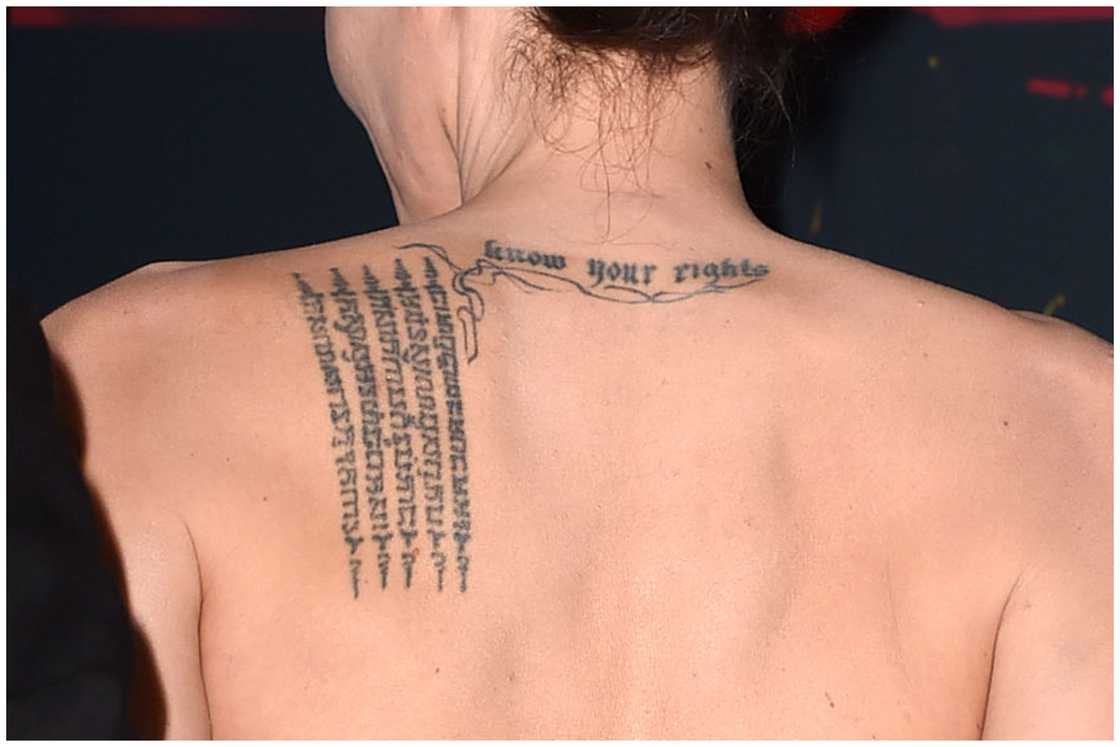 Angelina Jolie's Buddhist Pali tattoo on her upper left back at the 18th Annual Hollywood Film Awards at the Hollywood Palladium Angelina Jolie's Buddhist Pali tattoo on her upper left back at the 18th Annual Hollywood Film Awards at the Hollywood Palladium
