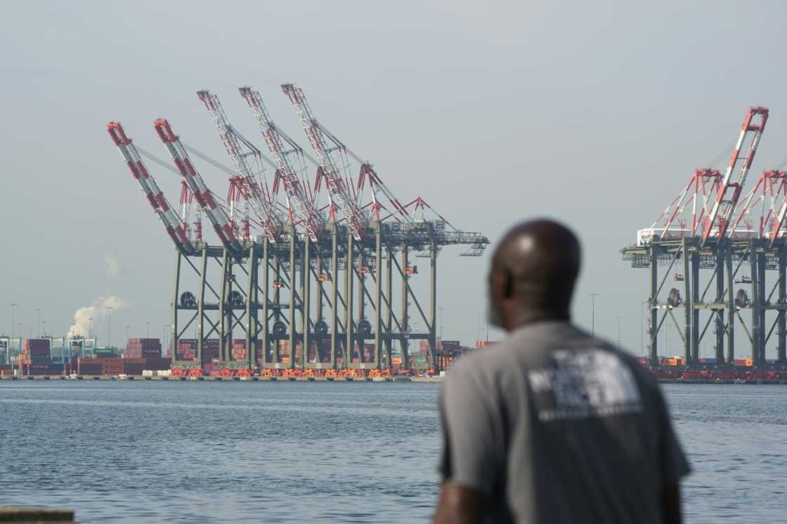 A man walks along a pier in Bayonne as cranes are visible at Port Newark in New Jersey, on October 4, 2024, where a port strike ended A man walks along a pier in Bayonne as cranes are visible at Port Newark in New Jersey, on October 4, 2024, where a port strike ended