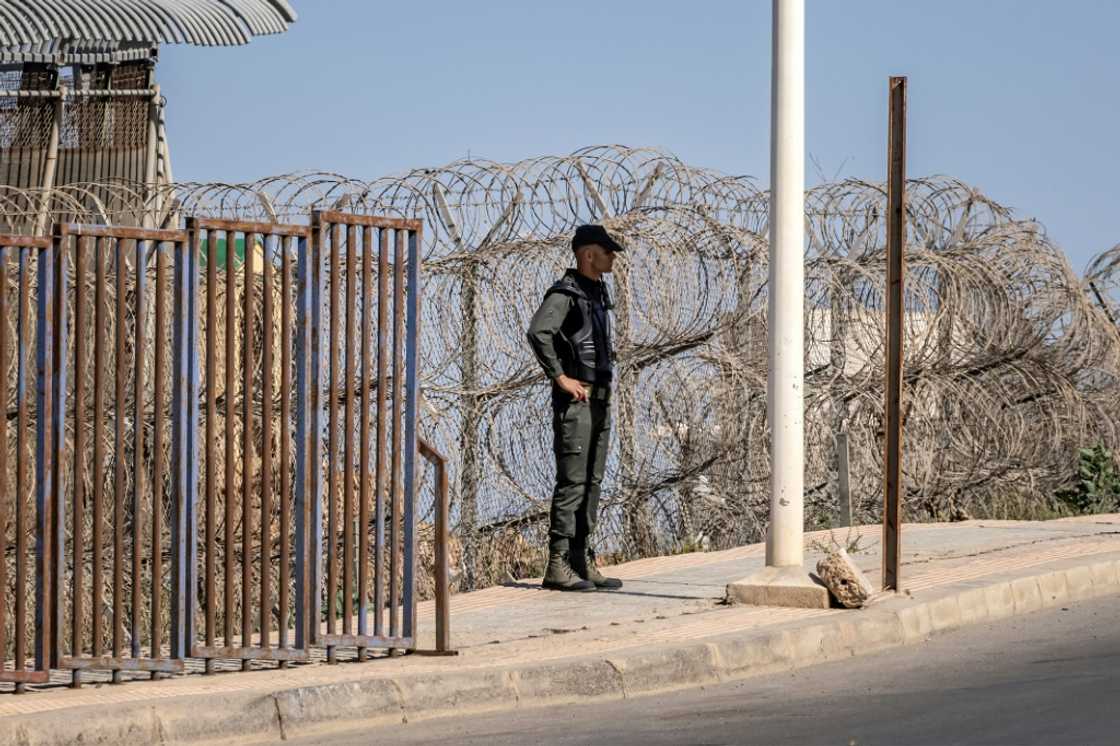 A Moroccan security officer stands guard on the border fence with Spain's North African Melilla enclave