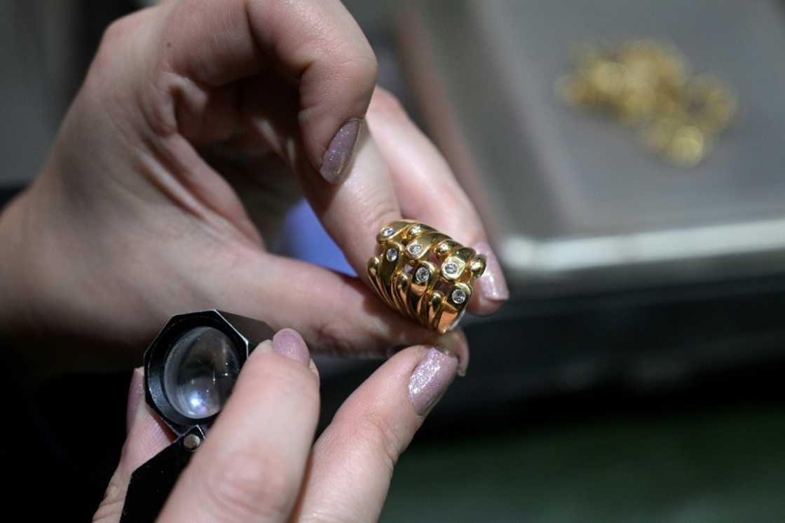 An appraiser examines a gold ring at a jewelry exchange in Buenos Aires An appraiser examines a gold ring at a jewelry exchange in Buenos Aires