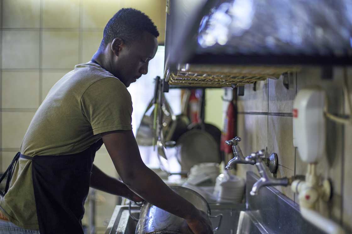 A man doing dishes in the kitchen A man doing dishes in the kitchen