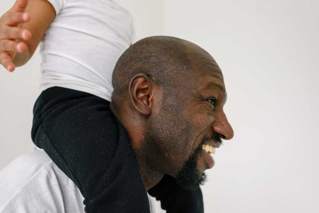 A father carries his young son on his shoulders. A father carries his young son on his shoulders.