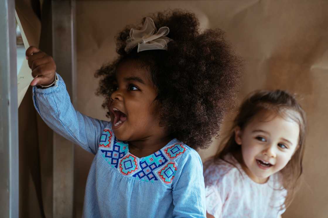 Two happy and curious young diverse girls Two happy and curious young diverse girls