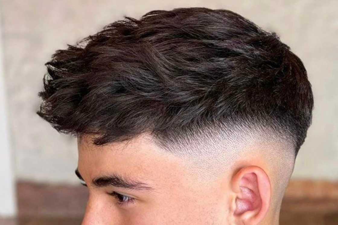 A white man is rocking a textured brush forward hairstyle A white man is rocking a textured brush forward hairstyle