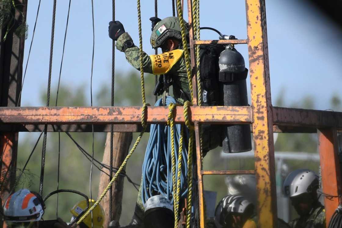 A soldier is lowered into a flooded mine in Mexico on Wednesday in a bid to reach 10 miners trapped inside A soldier is lowered into a flooded mine in Mexico on Wednesday in a bid to reach 10 miners trapped inside