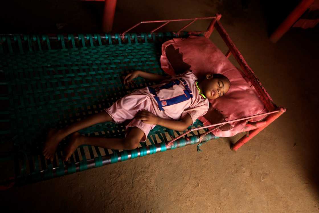 Talab, the youngest child of Awadya Ahmed, lies on a bed in the village of Banat in River Nile state, north of the Sudanese capital Khartoum. She says Talab was born after mining residues spread in the area
