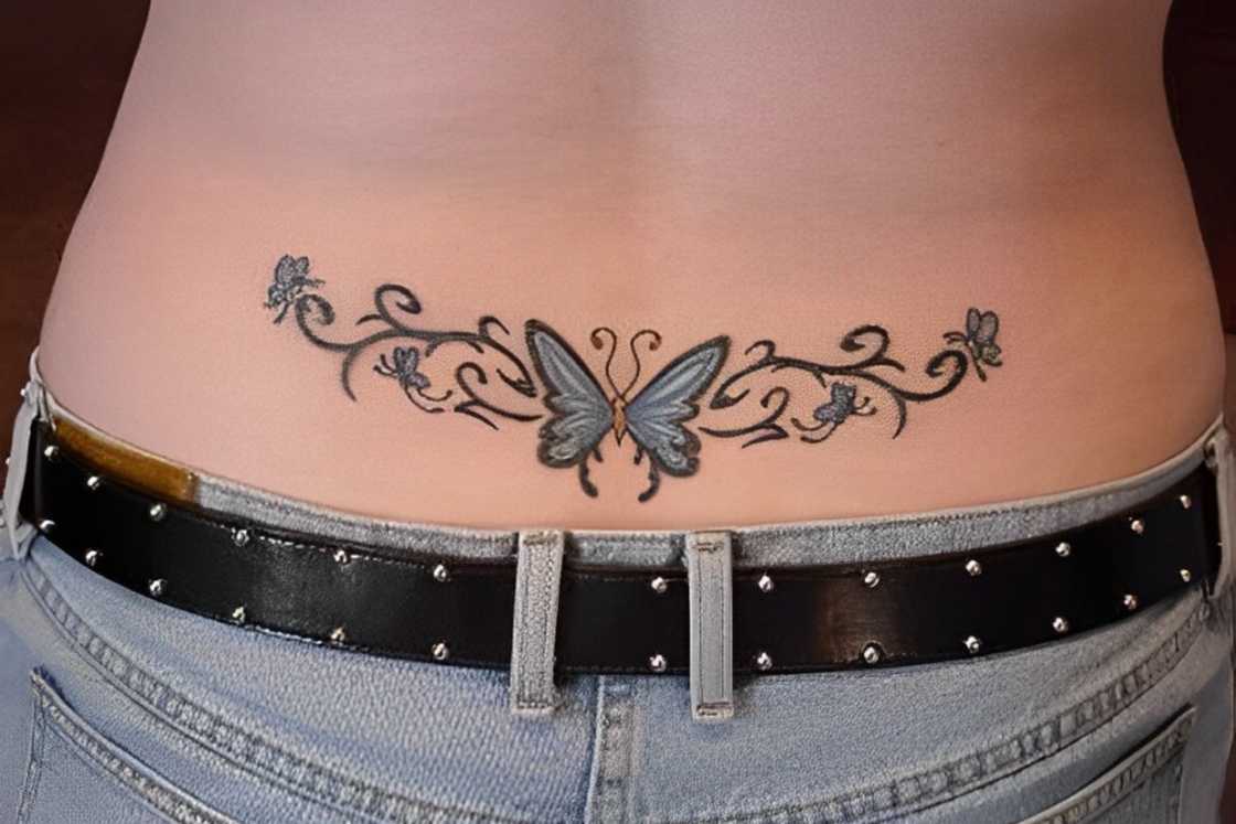 A man has a butterfly tattoo on his lower back A man has a butterfly tattoo on his lower back