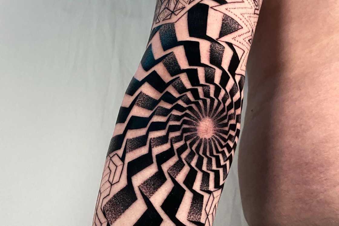 A full sleeve geometric illusion elbow tattoo A full sleeve geometric illusion elbow tattoo