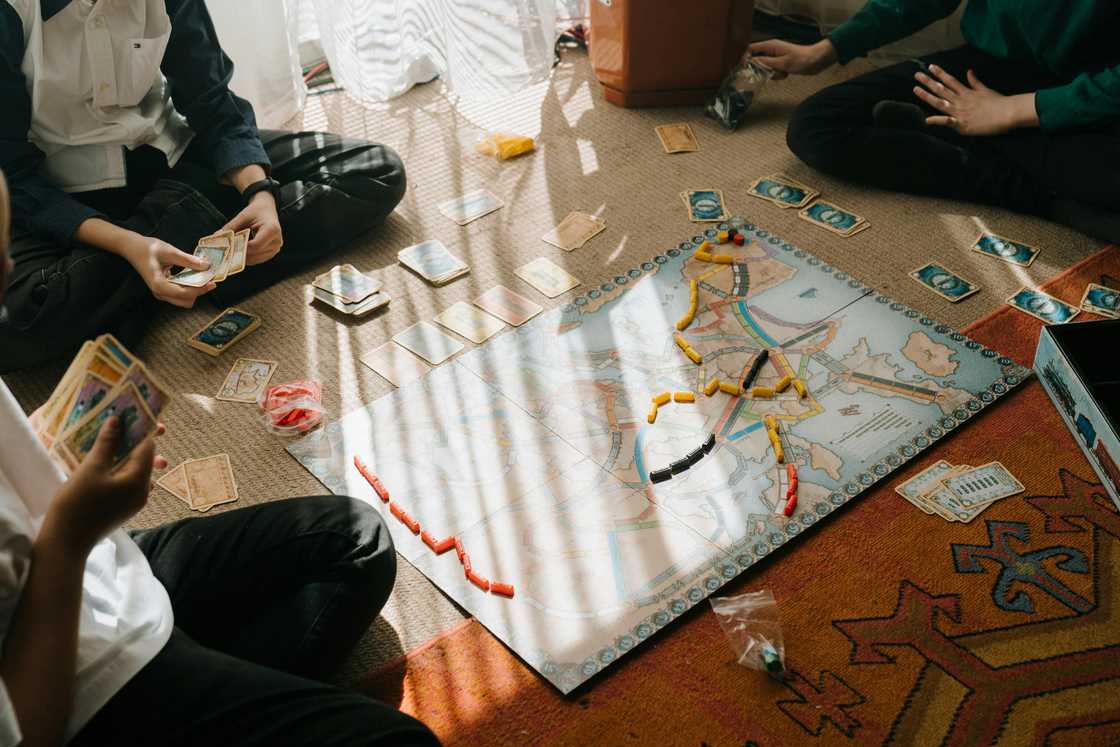 Three adults playing a board game Three adults playing a board game