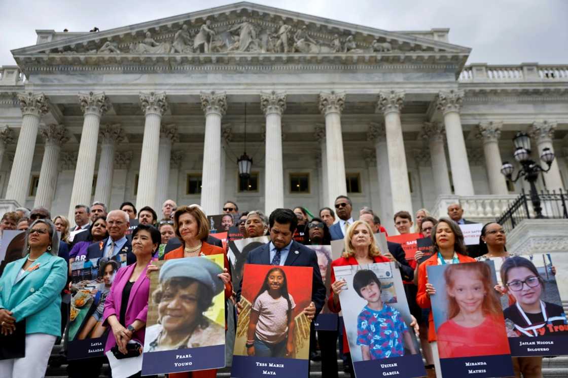 Speaker of the House Nancy Pelosi stands with fellow Democrats holding photographs of the victims of the mass shootings in Buffalo, New York and Uvalde, Texas, before passing the Bipartisan Safer Communities Act in front of the House of Representatives on June 24, 2022 Speaker of the House Nancy Pelosi stands with fellow Democrats holding photographs of the victims of the mass shootings in Buffalo, New York and Uvalde, Texas, before passing the Bipartisan Safer Communities Act in front of the House of Representatives on June 24, 2022