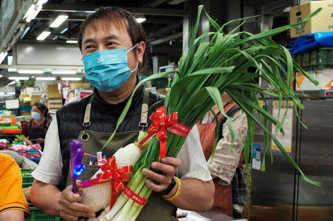 A Taipei greengrocer presents vegetables to a mayoral candidate A Taipei greengrocer presents vegetables to a mayoral candidate