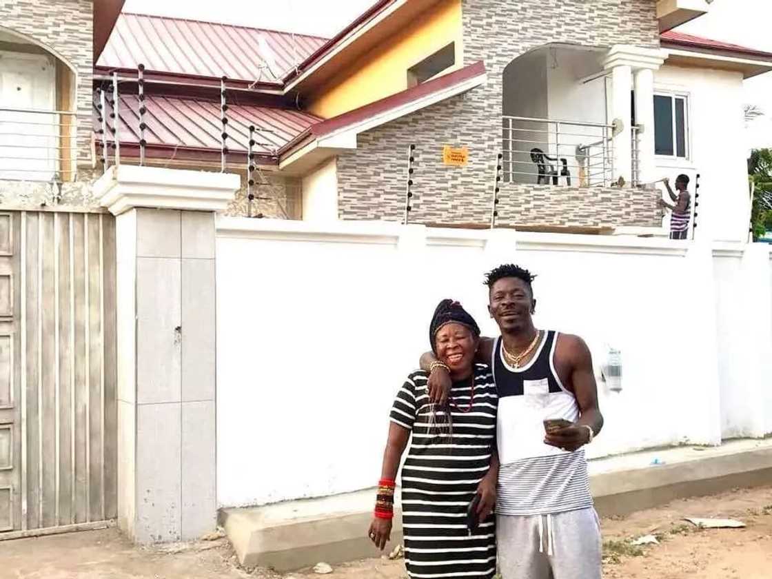 Shatta Wale and his mother standing in front of a house Shatta Wale and his mother standing in front of a house