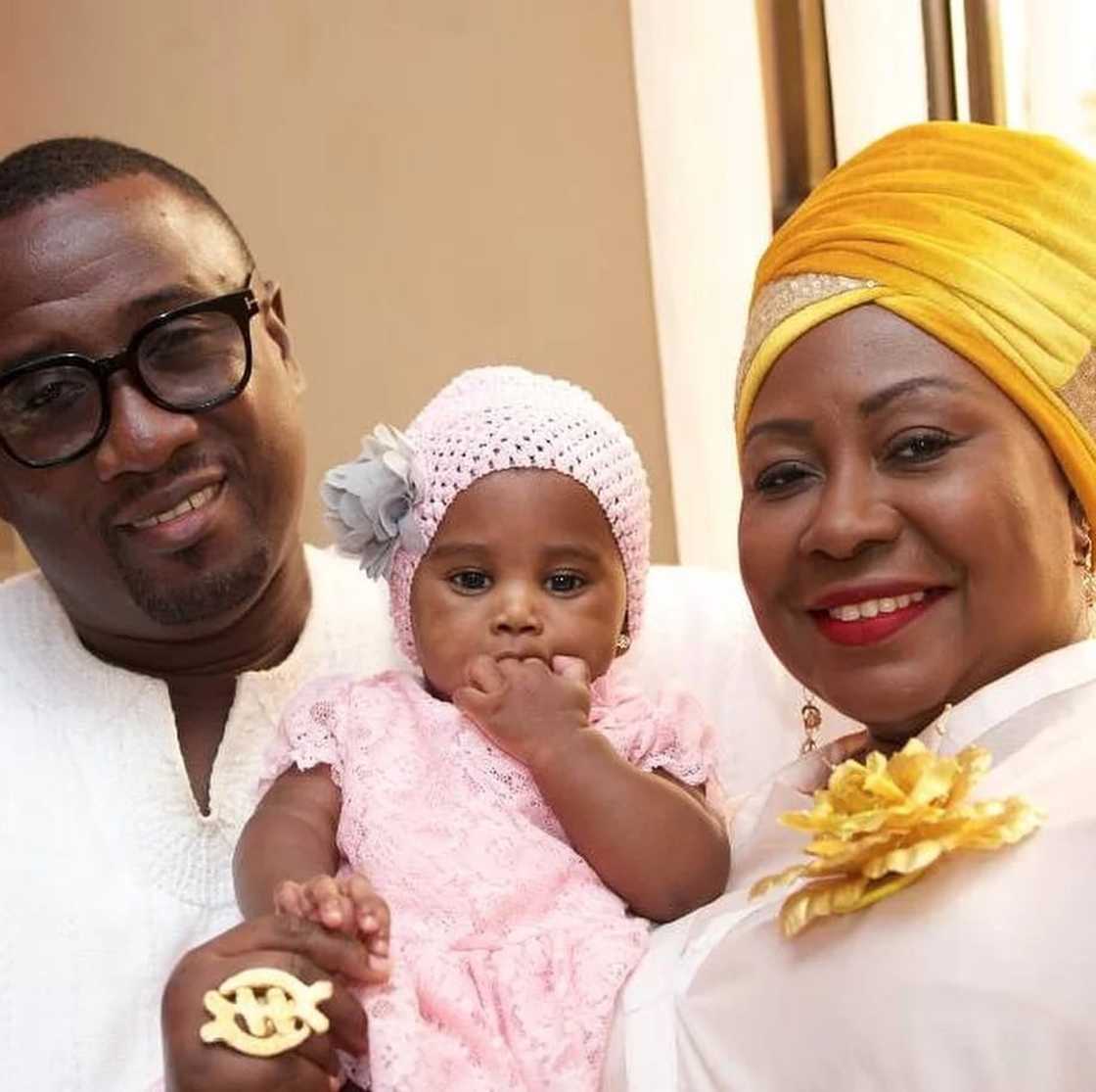 Gifty Anti and her husband smile as they hold their daughter