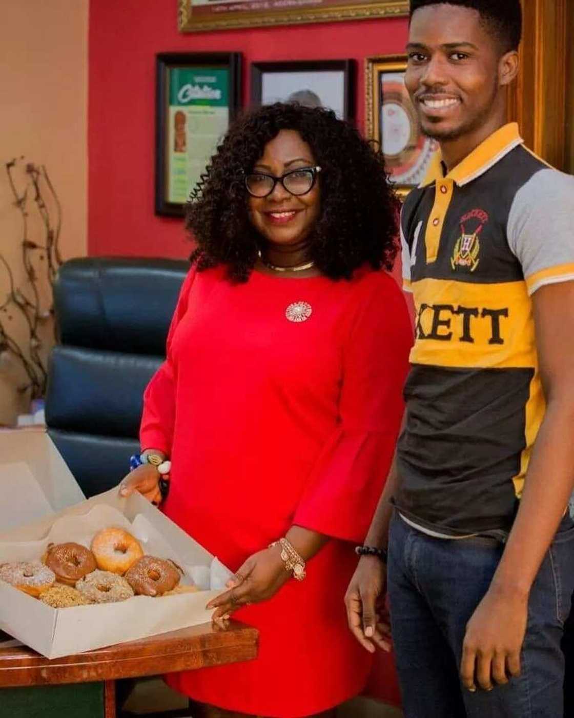 Gifty Anti opens a box of doughnuts with a man beside her Gifty Anti opens a box of doughnuts with a man beside her