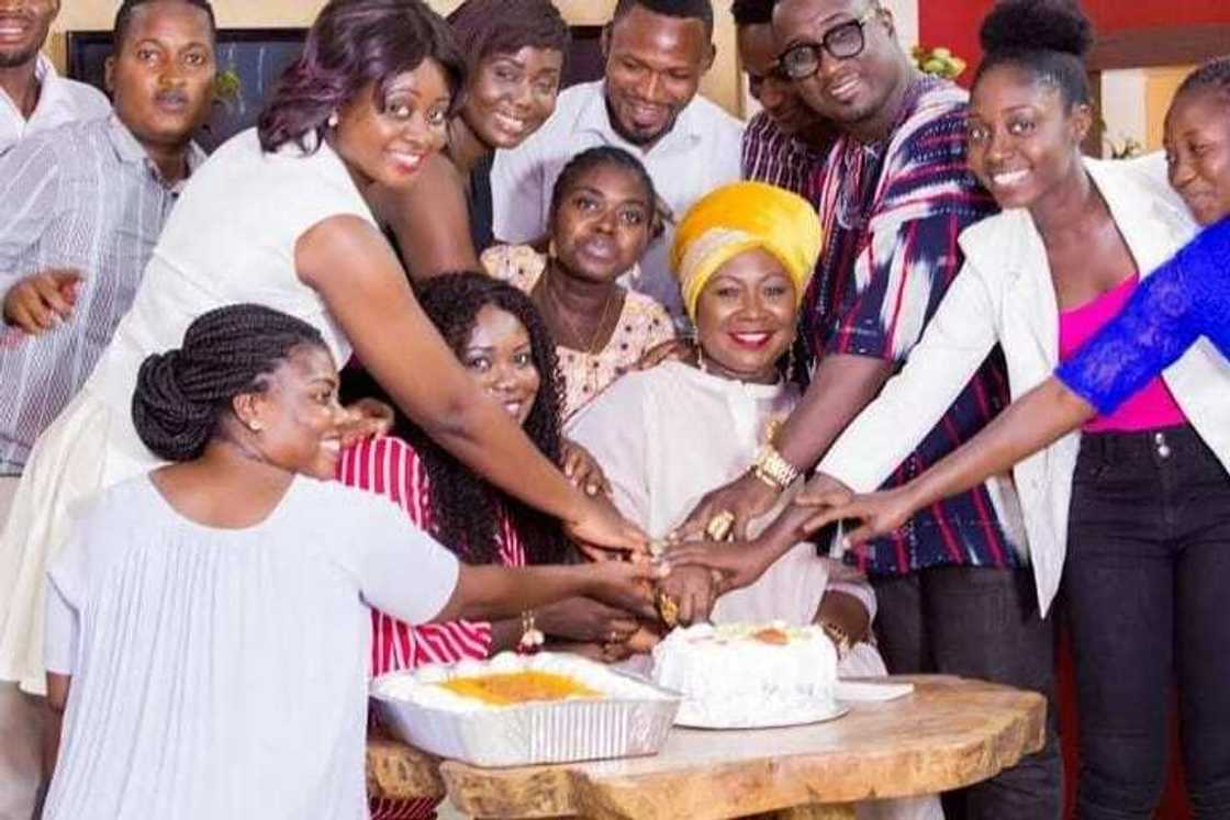 Gifty Anti cuts her cake with a group of people