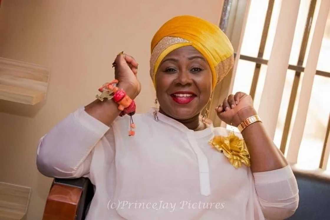 Gifty Anti in a yellow turban and white shirt similing