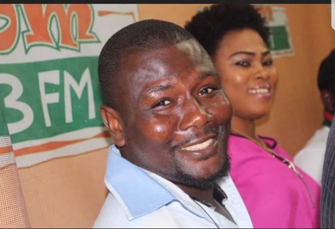 Man smiling with a woman behind him