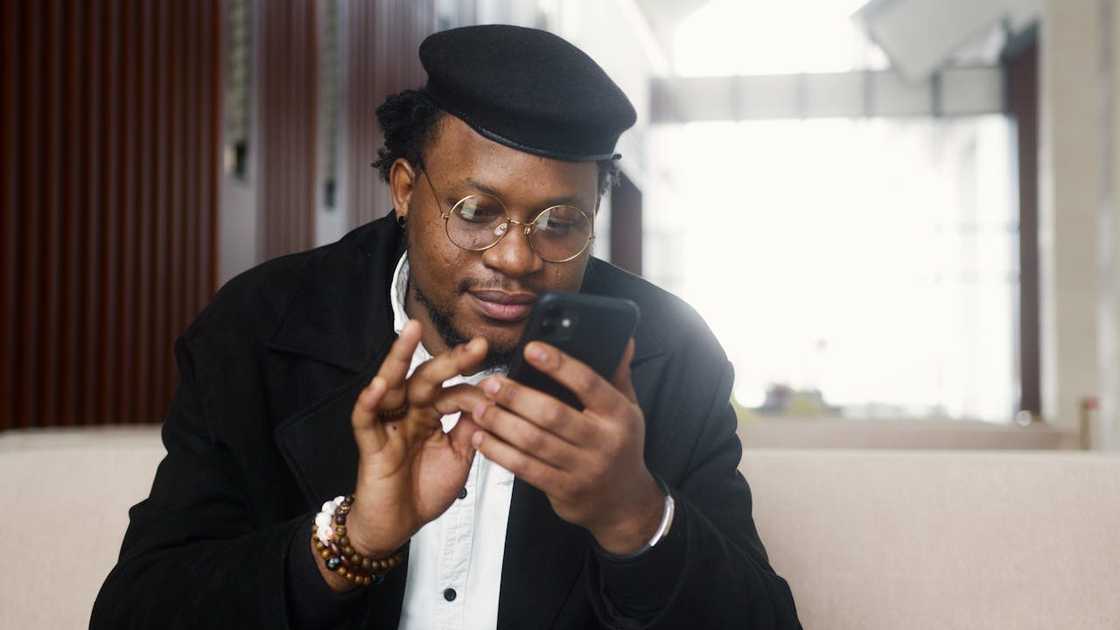 A man scrolls and looks at his phone.