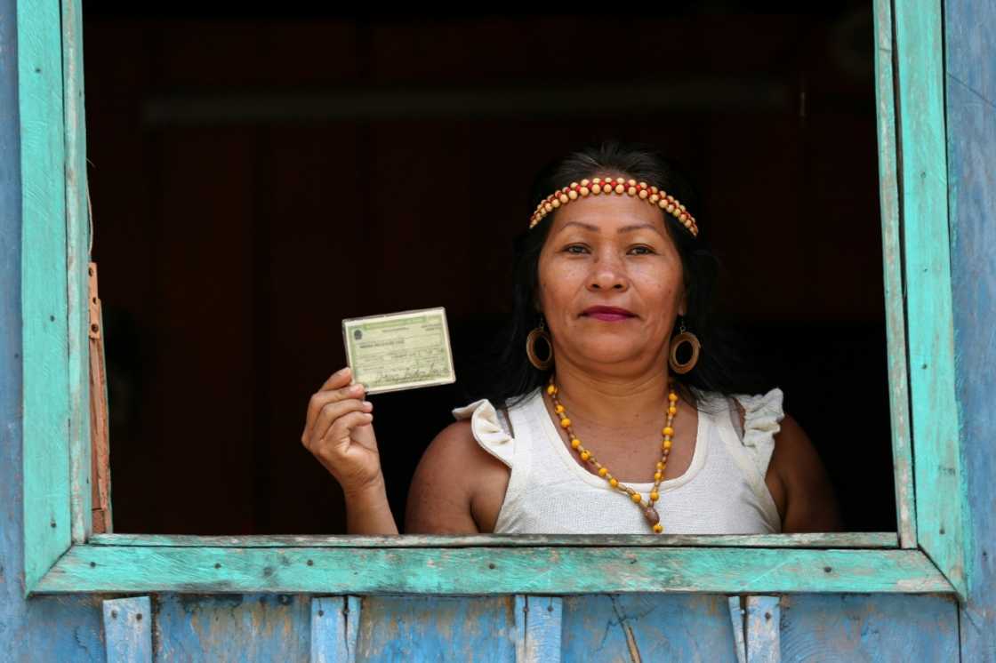 An indigenous Kambeba woman proudly displays her voter ID An indigenous Kambeba woman proudly displays her voter ID