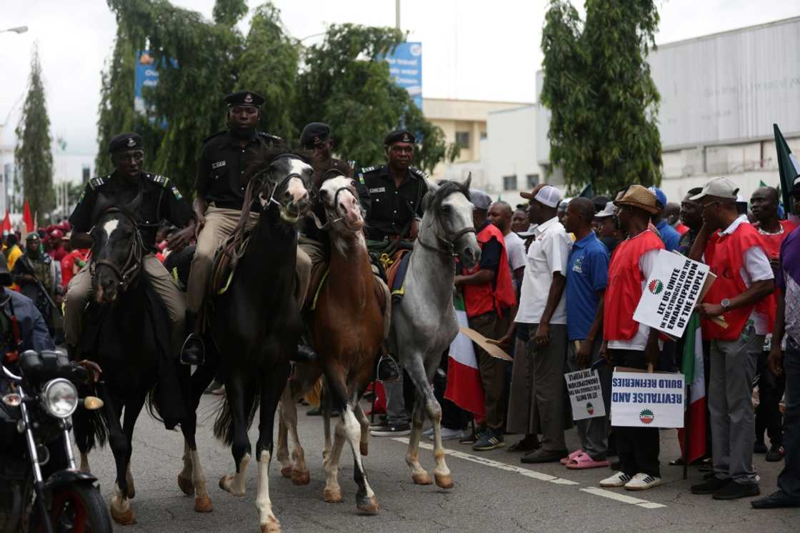 Mounted Nigerian police officers keep an eye on striking workers in Abuja Mounted Nigerian police officers keep an eye on striking workers in Abuja