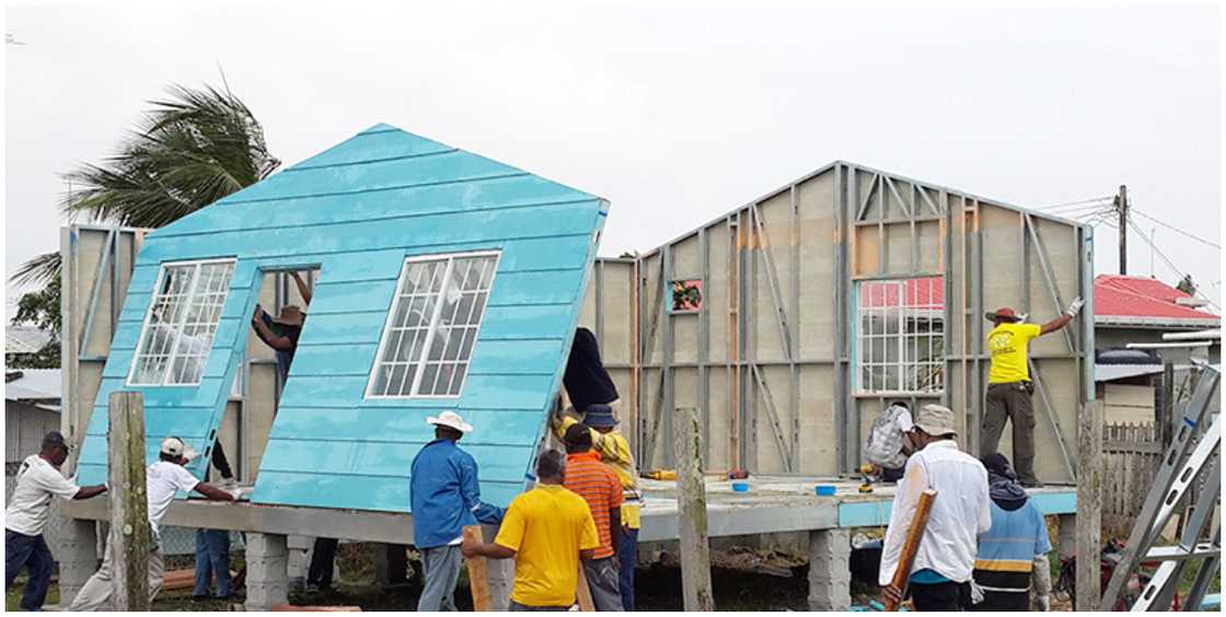 Workers put together a wooden house