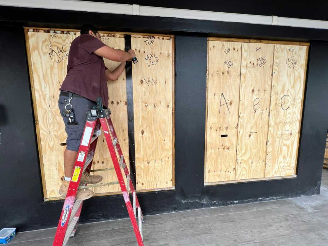 A man boards up a store in Hamilton, Bermuda on September 22, 2022 as Hurricane Fiona churns towards the Atlantic island A man boards up a store in Hamilton, Bermuda on September 22, 2022 as Hurricane Fiona churns towards the Atlantic island