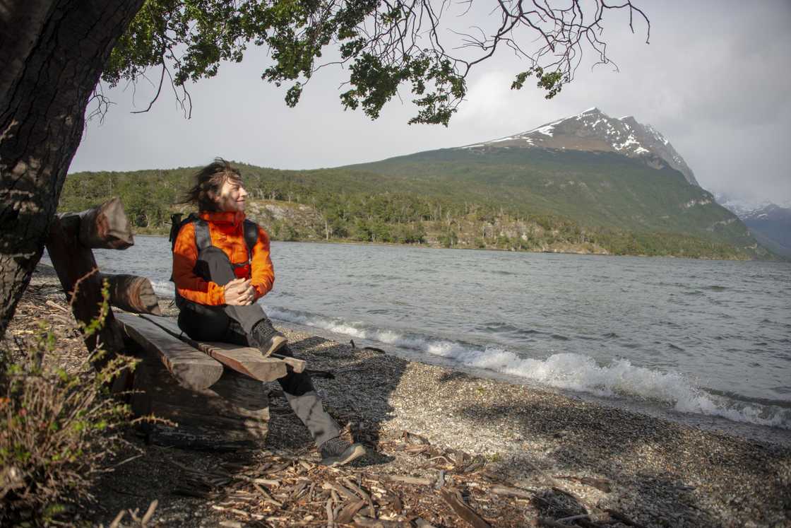 A female hiker rests on the bench on the shore of Lake Acigami A female hiker rests on the bench on the shore of Lake Acigami